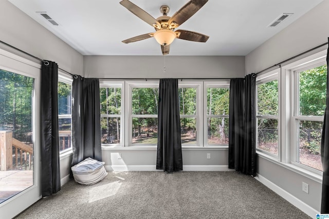 unfurnished sunroom featuring ceiling fan