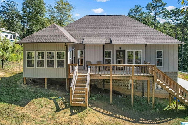 rear view of property with a deck and a yard