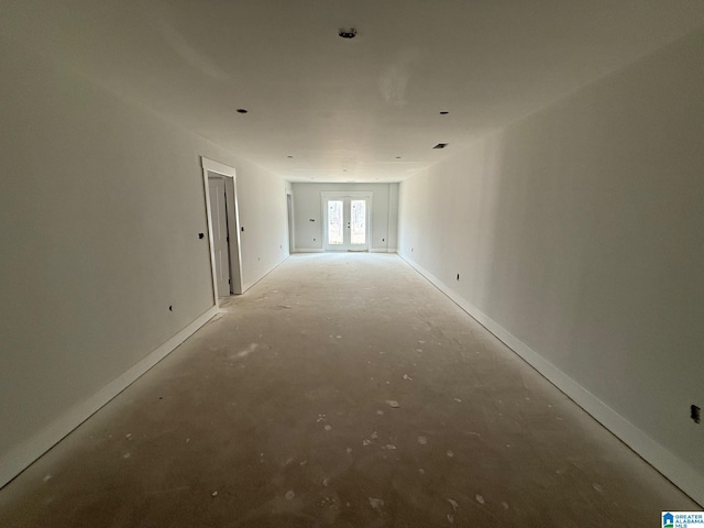 unfurnished room featuring french doors and baseboards