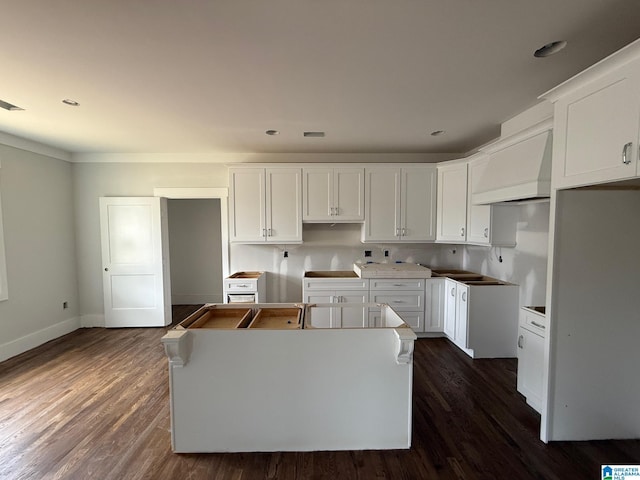 kitchen featuring white cabinets, a center island, dark wood-type flooring, and premium range hood