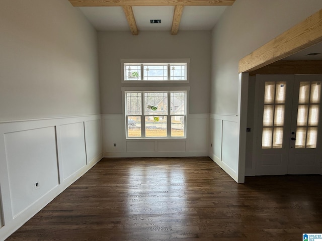 interior space with visible vents, dark wood-type flooring, a wainscoted wall, beam ceiling, and french doors