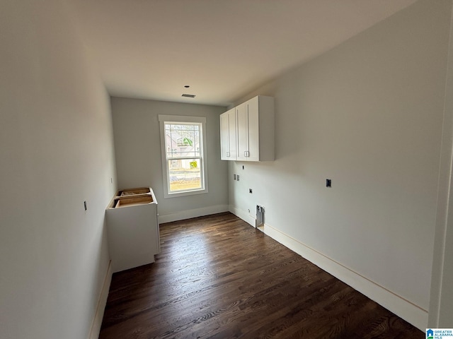 unfurnished room featuring visible vents, baseboards, and dark wood-style flooring