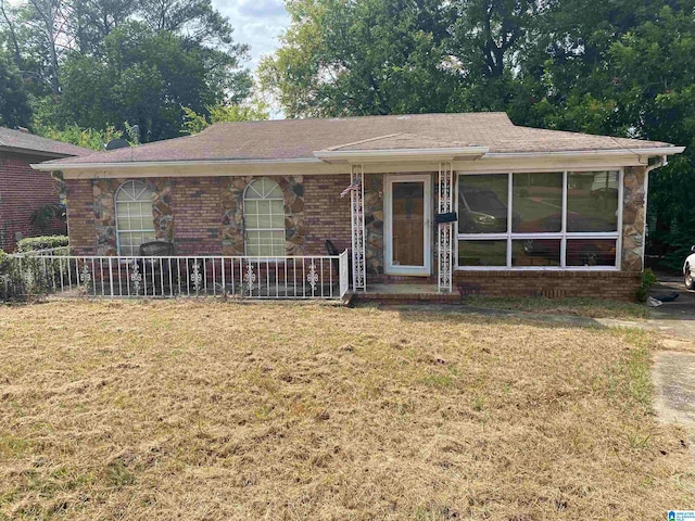 view of front of house with a sunroom and a front lawn