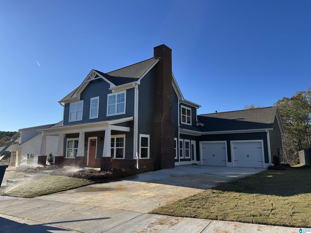 view of front facade with a garage, a front lawn, and covered porch