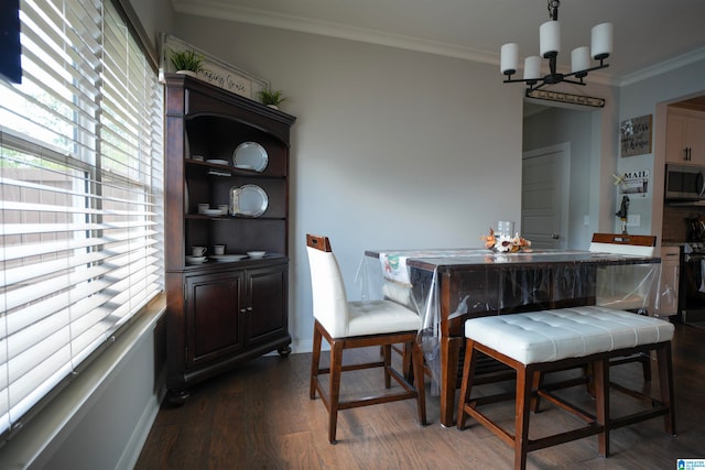 dining space with ornamental molding, a chandelier, and dark hardwood / wood-style floors