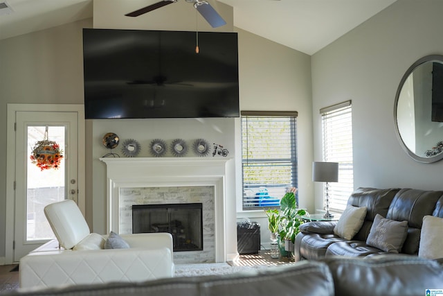 living room with ceiling fan, a premium fireplace, and vaulted ceiling