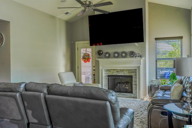 living room with a stone fireplace, lofted ceiling, and ceiling fan