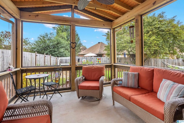 sunroom / solarium featuring a wealth of natural light, vaulted ceiling with beams, ceiling fan, and wood ceiling