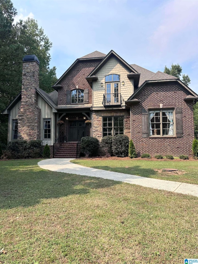 view of front facade featuring a balcony and a front lawn