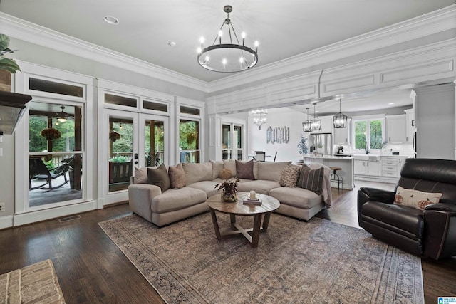 living room featuring sink, crown molding, french doors, and dark hardwood / wood-style flooring