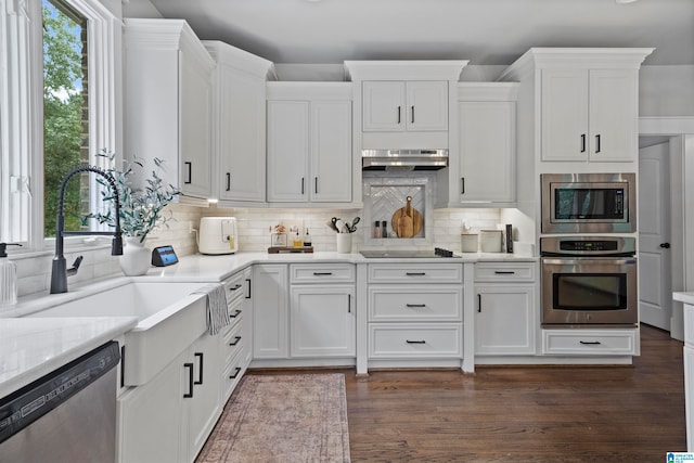 kitchen with white cabinetry, backsplash, dark hardwood / wood-style flooring, stainless steel appliances, and exhaust hood