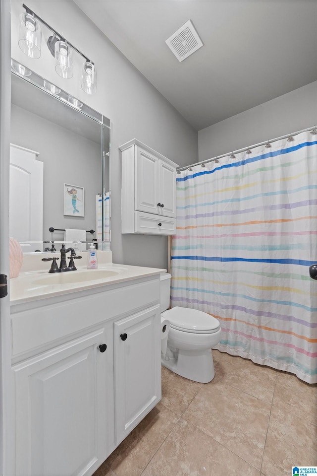 bathroom featuring walk in shower, vanity, toilet, and tile patterned floors