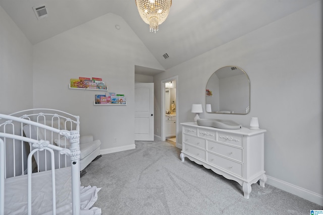 bedroom featuring an inviting chandelier, light colored carpet, ensuite bathroom, and vaulted ceiling