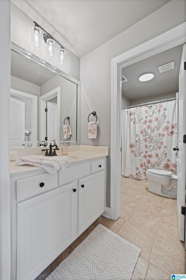 bathroom featuring tile patterned flooring, vanity, and toilet