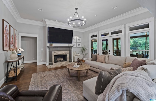 living room featuring french doors, dark hardwood / wood-style floors, an inviting chandelier, a fireplace, and crown molding