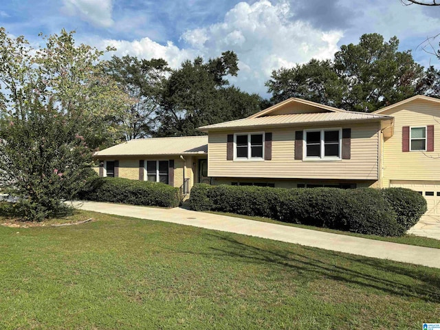 split level home featuring a garage and a front lawn