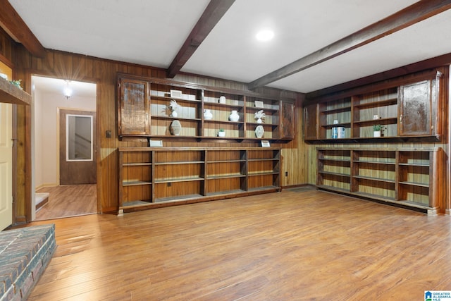 bar featuring wooden walls, beamed ceiling, and light wood finished floors