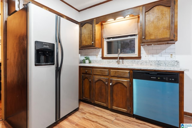 kitchen with decorative backsplash, stainless steel appliances, ornamental molding, sink, and light hardwood / wood-style floors