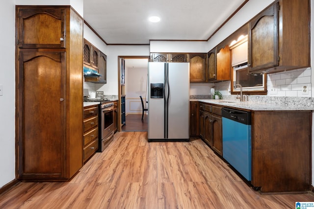 kitchen featuring stainless steel appliances, ornamental molding, sink, light hardwood / wood-style floors, and tasteful backsplash