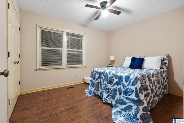 bedroom featuring a textured ceiling, dark hardwood / wood-style floors, and ceiling fan