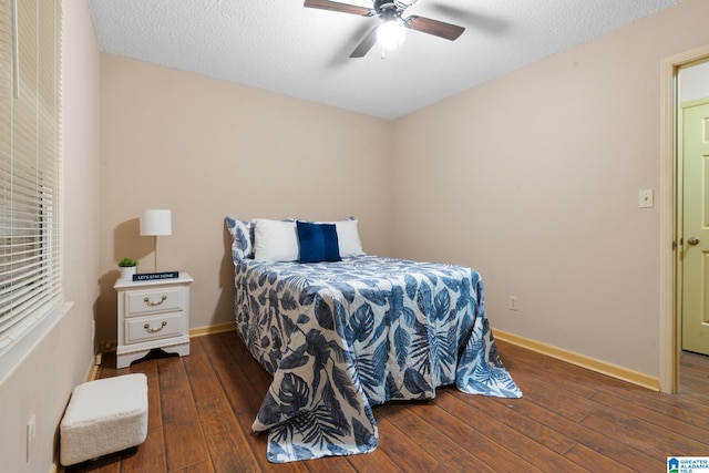 bedroom featuring a textured ceiling, dark wood-type flooring, and ceiling fan