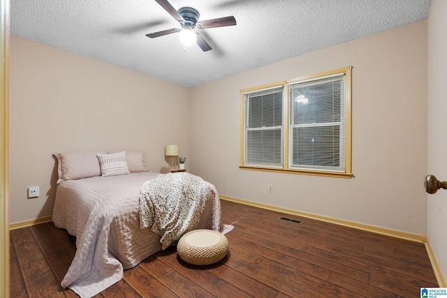 bedroom featuring visible vents, hardwood / wood-style floors, baseboards, ceiling fan, and a textured ceiling