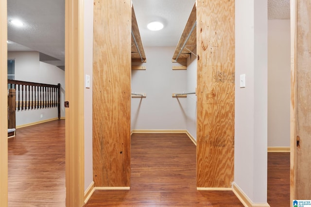walk in closet with wood finished floors