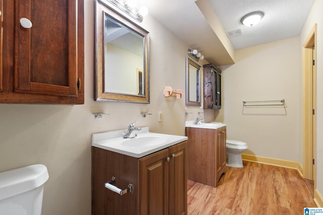 bathroom with vanity, hardwood / wood-style floors, a textured ceiling, and toilet