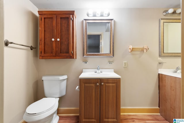 bathroom featuring toilet, wood finished floors, and vanity