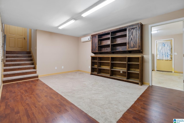 basement featuring dark wood-type flooring and a wall mounted air conditioner