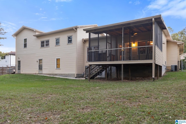 back of property with a yard, a sunroom, and central AC