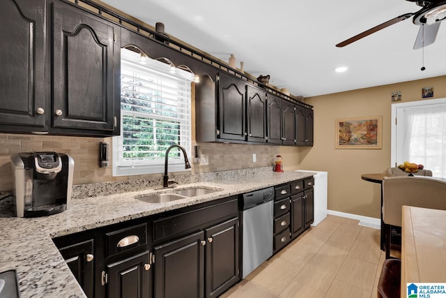 kitchen featuring decorative backsplash, stainless steel dishwasher, light stone countertops, and sink