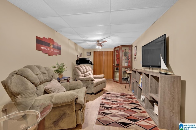 living room with a paneled ceiling, ceiling fan, and hardwood / wood-style floors