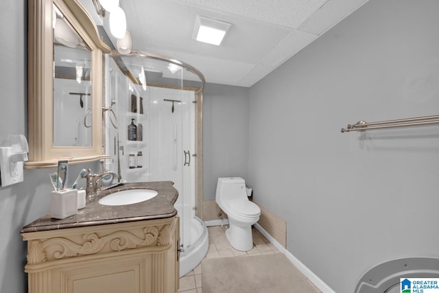 bathroom featuring tile patterned floors, a shower with door, vanity, and toilet