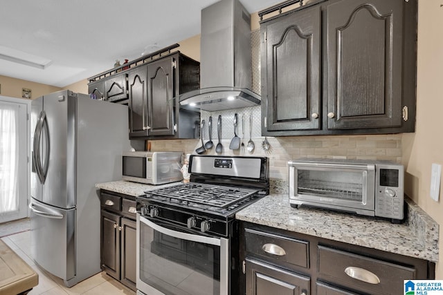 kitchen featuring appliances with stainless steel finishes, backsplash, light tile patterned floors, and wall chimney range hood