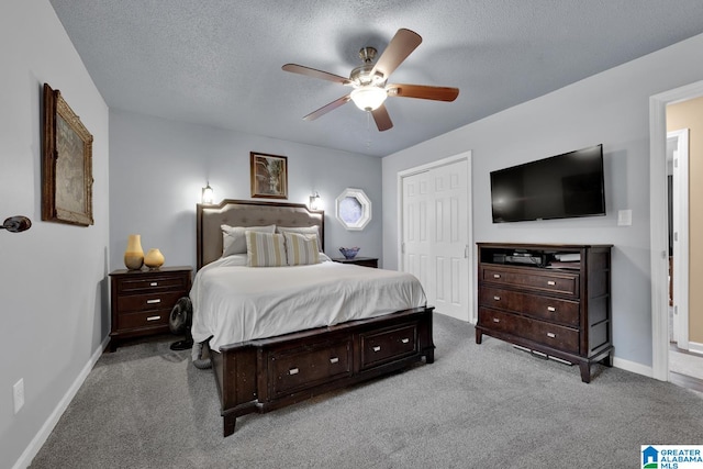 bedroom featuring ceiling fan, a closet, light carpet, and a textured ceiling