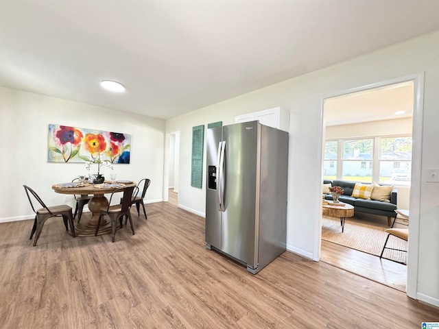 kitchen featuring stainless steel refrigerator with ice dispenser, light hardwood / wood-style flooring, and white cabinets