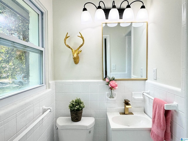 bathroom with tile walls, vanity, and toilet