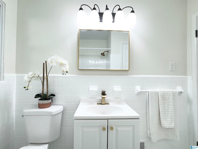 bathroom with tile walls, vanity, and toilet