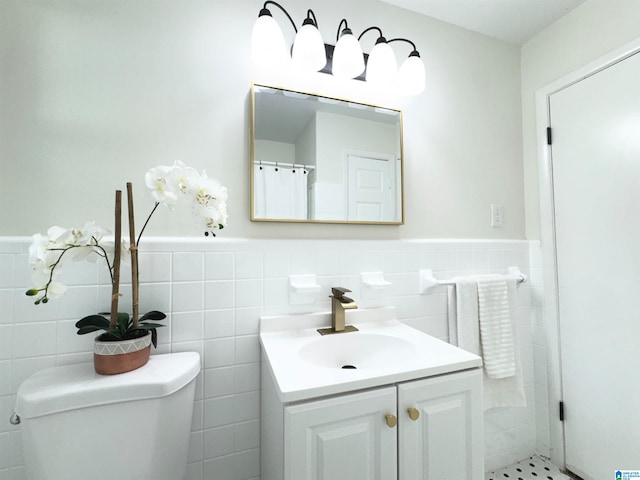 bathroom featuring tile walls, vanity, and toilet