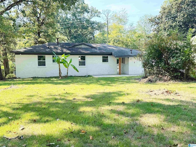 rear view of house featuring a lawn and a patio area