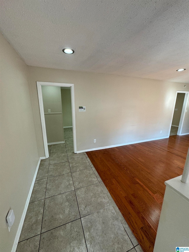 empty room with hardwood / wood-style flooring and a textured ceiling