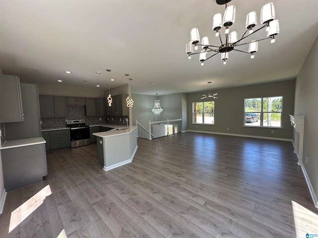 kitchen with sink, hanging light fixtures, gray cabinetry, stainless steel electric stove, and hardwood / wood-style floors