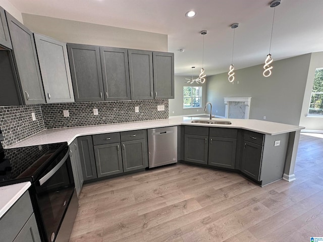 kitchen featuring sink, kitchen peninsula, black electric range, decorative light fixtures, and dishwasher