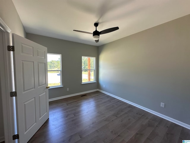 empty room featuring ceiling fan and dark wood-type flooring