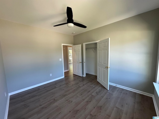 unfurnished bedroom featuring dark hardwood / wood-style flooring, ceiling fan, and a closet