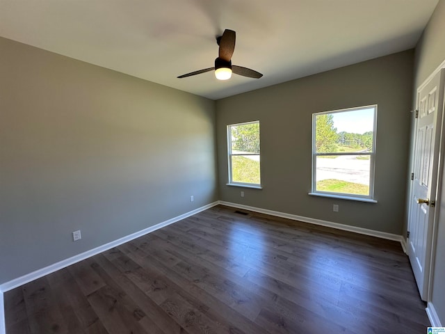 empty room with dark hardwood / wood-style flooring and ceiling fan