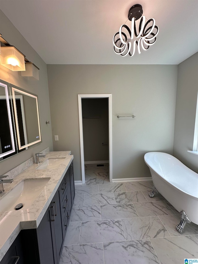 bathroom featuring a bathtub, vanity, and a notable chandelier