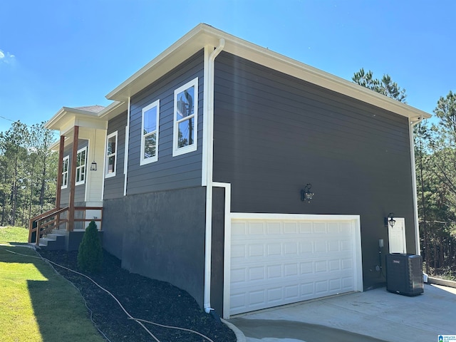 view of side of property featuring a garage and central AC unit