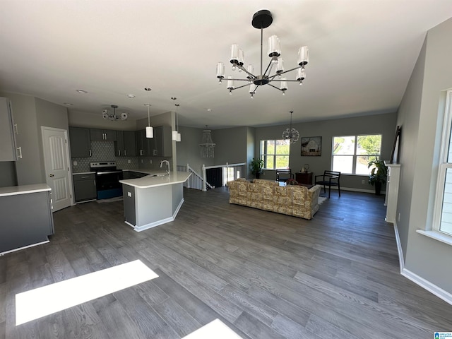 kitchen featuring dark hardwood / wood-style floors, sink, an island with sink, hanging light fixtures, and backsplash